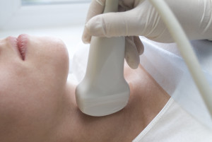Scanning the neck to check a thyroid with an ultrasound