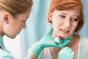 photo of a medical staff member treating a young woman's chin scrape